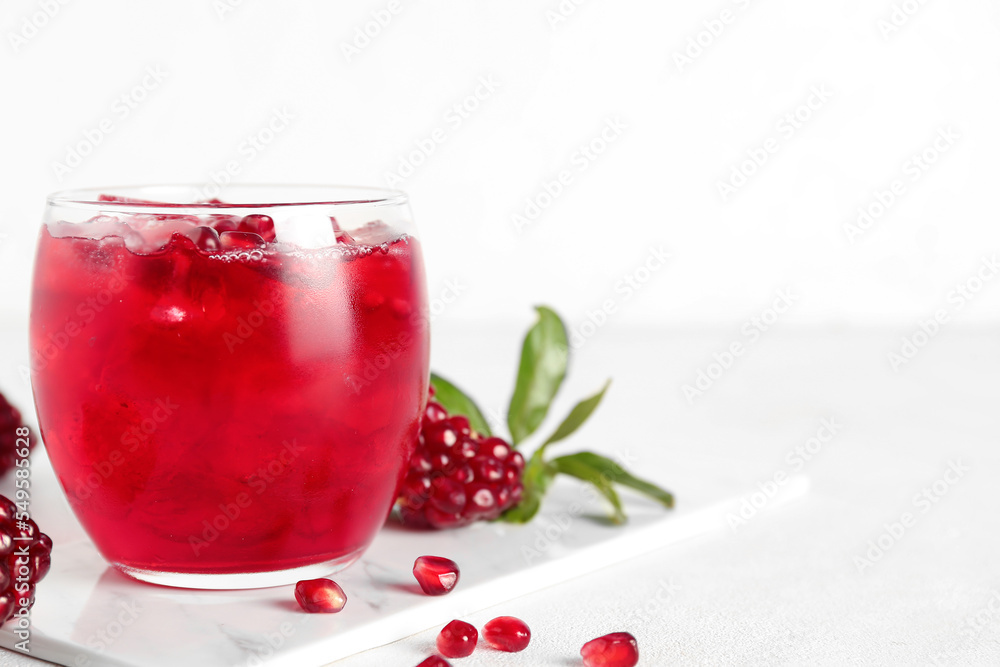 Glass of cold pomegranate juice on light background Glass of cold pomegranate juice on light background