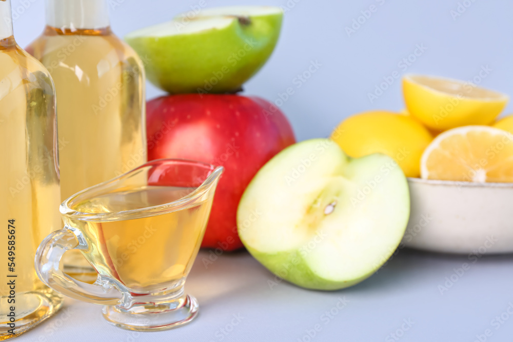 Gravy boat with apple cider vinegar on light background, closeup Gravy boat with apple cider vinegar on light background, closeup
