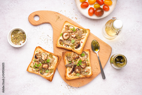 Wallpaper Mural Wooden board of tasty toasts with cream cheese, mushrooms and pesto sauce on light background Torontodigital.ca