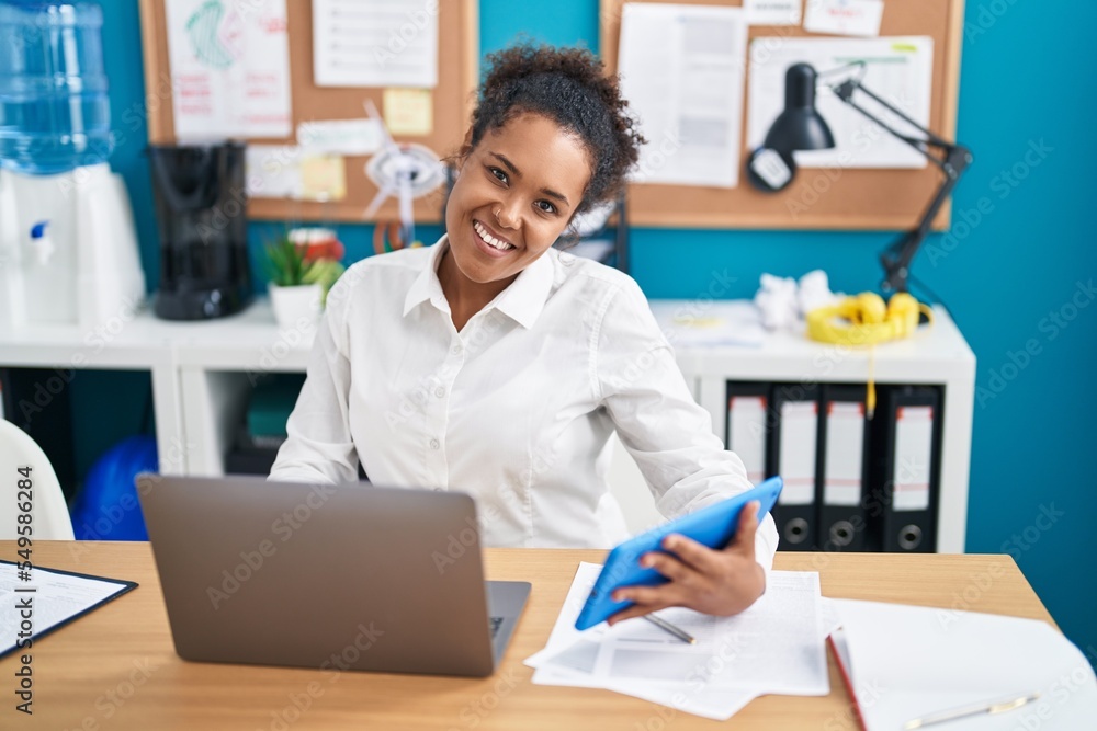 African american woman business worker using laptop and touchpad at office African american woman business worker using laptop and touchpad at office