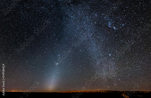 Phenomenon called zodiacal light and also the milk way is shown in the night time sky in above an outdoor field. Digitally enhanced. Elements of this image furnished by NASA.
