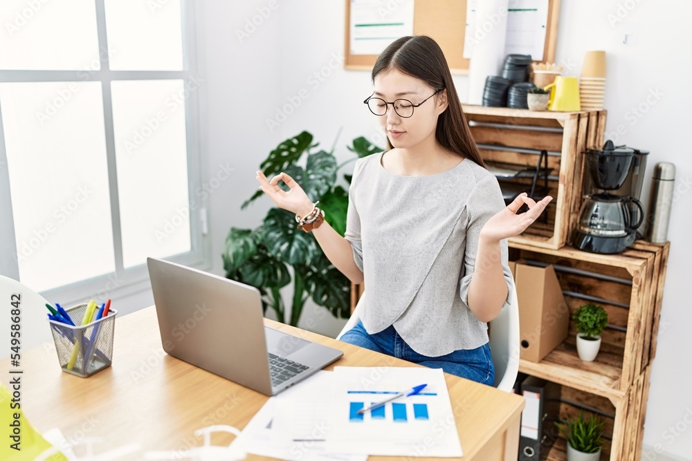 Young asian woman relaxing and meditating at the office Young asian woman relaxing and meditating at the office