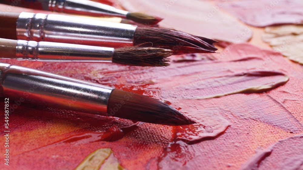 Obraz premium Many brushes on artist's palette with mixed paints, closeup