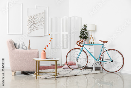 Interior of living room with bicycle, armchair and Christmas tree