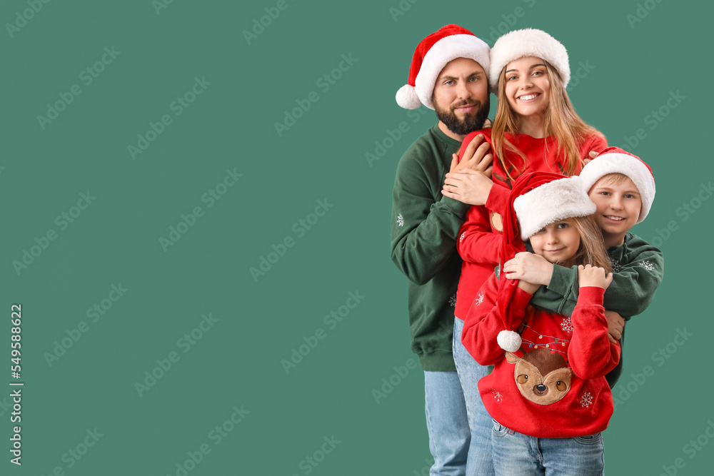 Happy family in Santa hats hugging on green background Happy family in Santa hats hugging on green background