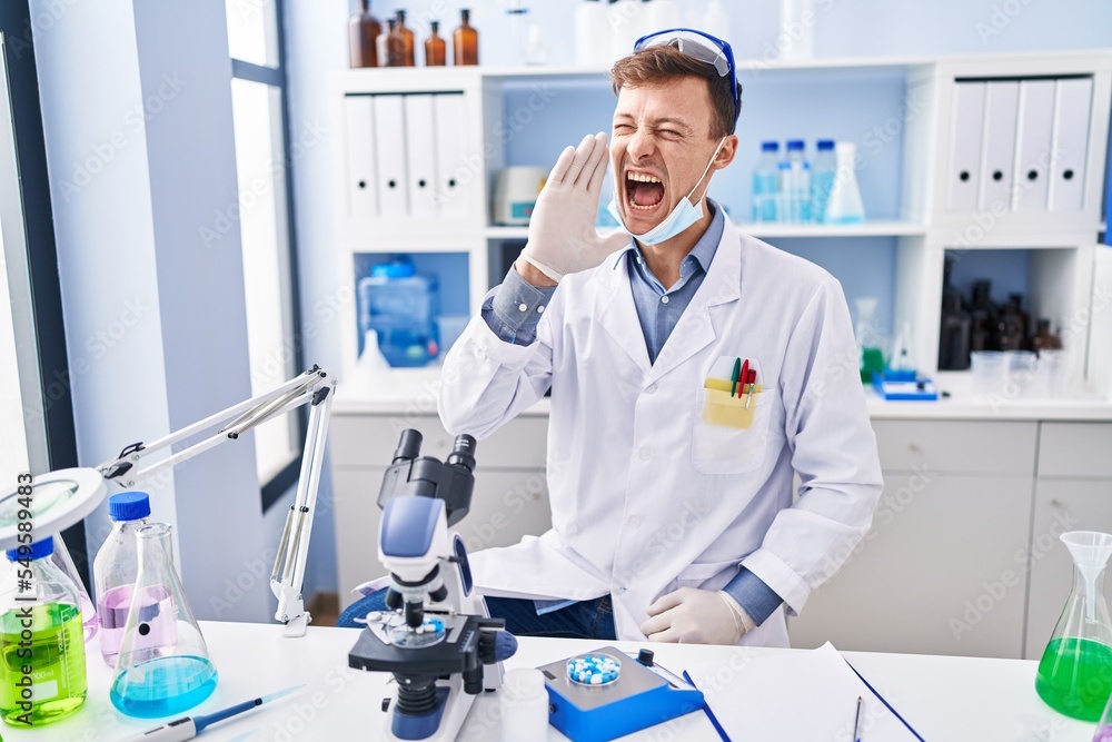 Caucasian man working at scientist laboratory clueless and confused with open arms, no idea and doubtful face. Caucasian man working at scientist laboratory clueless and confused with open arms, no idea and doubtful face.