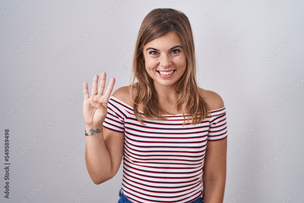 Young hispanic woman standing over isolated background showing and pointing up with fingers number four while smiling confident and happy. Young hispanic woman standing over isolated background showing and pointing up with fingers number four while smiling confident and happy.