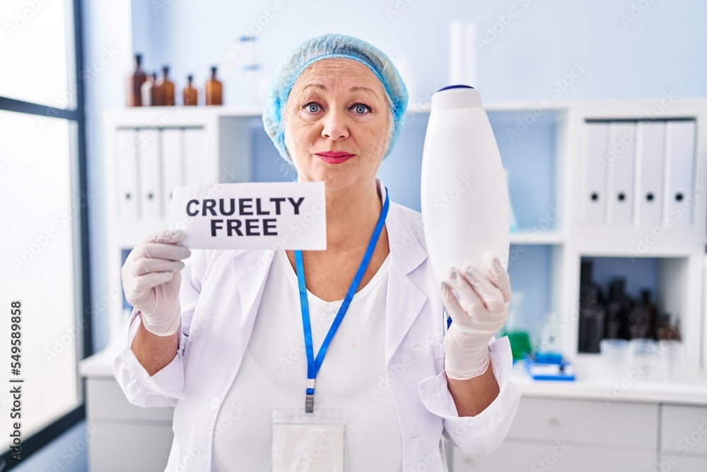 Middle age caucasian woman working on cruelty free laboratory relaxed with serious expression on face. simple and natural looking at the camera.