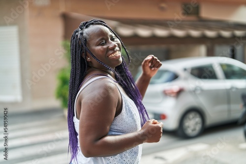 African american woman smiling confident dancing at coffee shop terrace