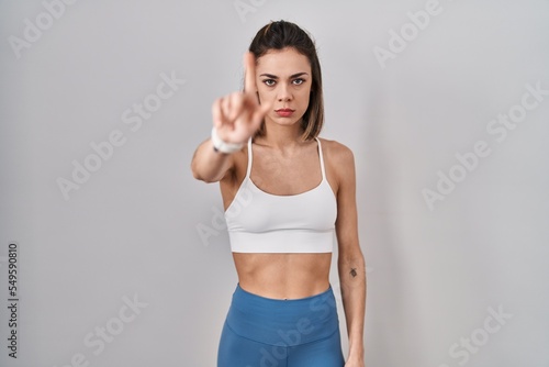 Hispanic woman wearing sportswear over isolated background pointing with finger up and angry expression, showing no gesture © Krakenimages.com