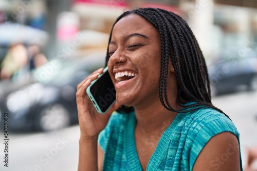 African american woman smiling confident talking on the smartphone at street