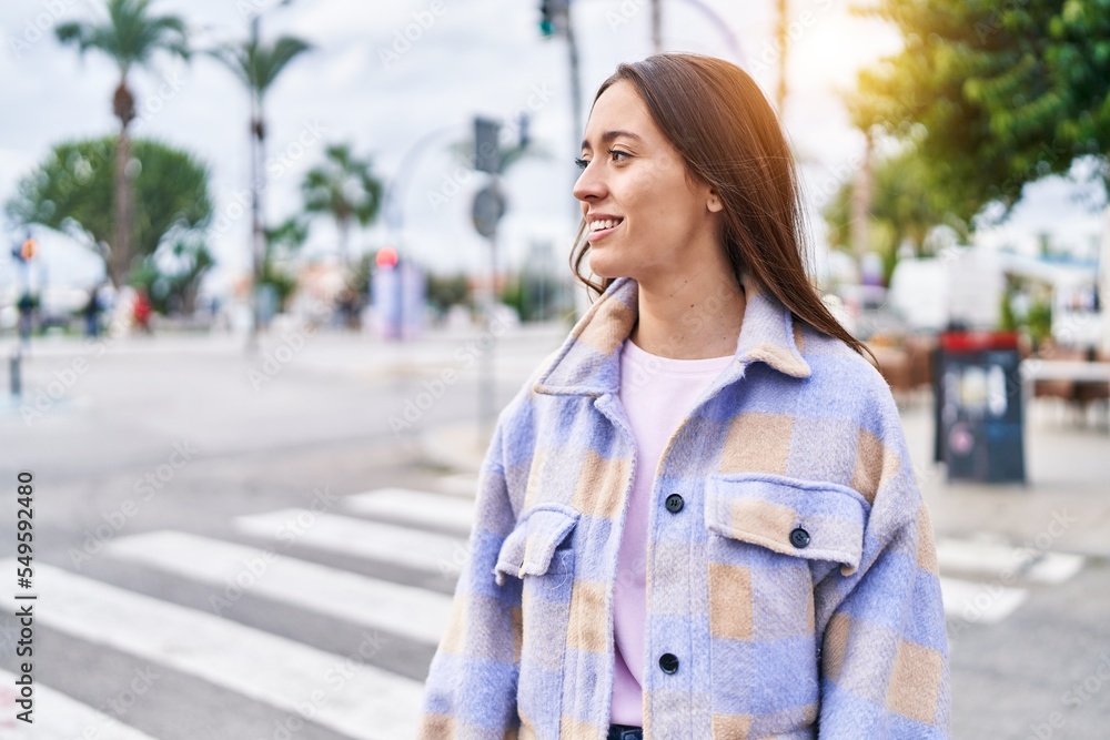 Fototapeta premium Young beautiful hispanic woman smiling confident looking to the side at street
