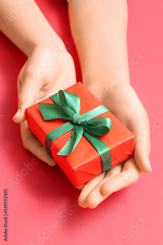 Fototapeta Naklejka Na Ścianę i Meble -  Woman with Christmas gift box on red background, closeup
