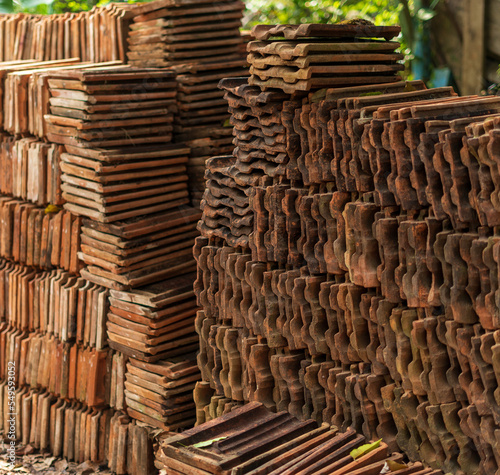 Long receding row of red roof tiles stacked