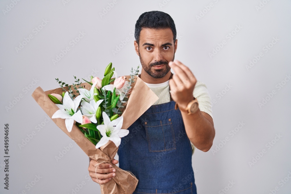 Hispanic man with beard working as florist doing italian gesture with hand and fingers confident expression Hispanic man with beard working as florist doing italian gesture with hand and fingers confident expression