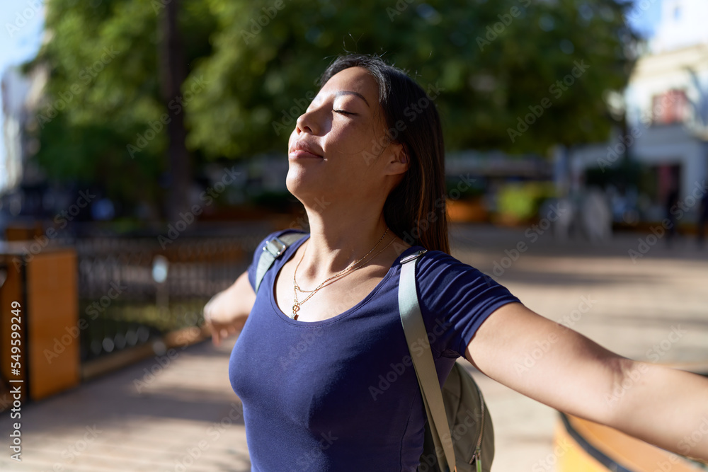 Young asian woman breathing with closed eyes at park