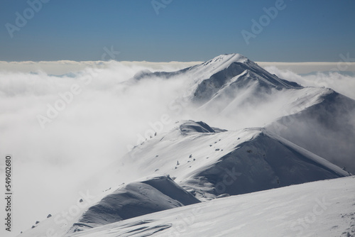 Snowy mountain against the background of a large massive Marmaros mountain range © almostfuture
