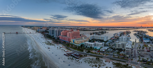 Row of hotels line Clearwater beach near Tampa with white sand colorful sunrise sky