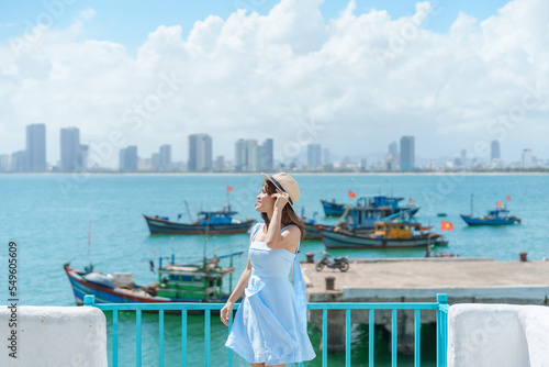 Woman traveler visiting at Son Tra marina. Tourist with blue dress and hat traveling in Da Nang city. Vietnam and Southeast Asia travel concept