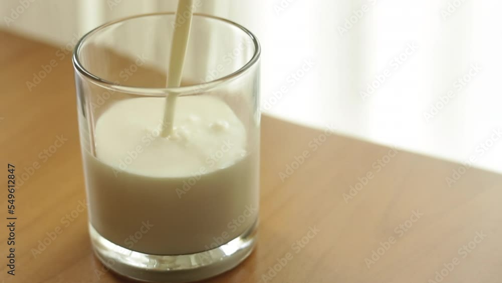 Pouring Homemade Kefir Into Glass, Yogurt or Buttermilk A Healthy Fermented Probiotic Dairy Superfood Drink, copy space left Pouring Homemade Kefir Into Glass, Yogurt or Buttermilk A Healthy Fermented Probiotic Dairy Superfood Drink, copy space left