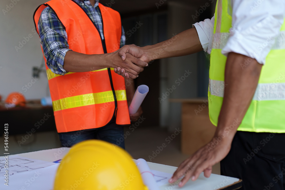 Architect and engineer construction workers shaking hands after finish an agreement in the office construction site, success collaboration concept Architect and engineer construction workers shaking hands after finish an agreement in the office construction site, success collaboration concept
