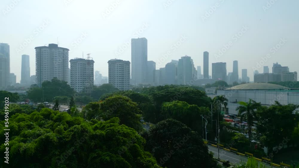 Drone view of trees with misty Jakarta cityscape Drone view of trees with misty Jakarta cityscape