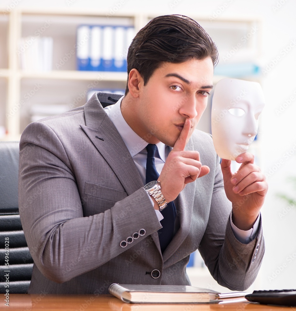 Businessman with mask in office hypocrisy concept Businessman with mask in office hypocrisy concept