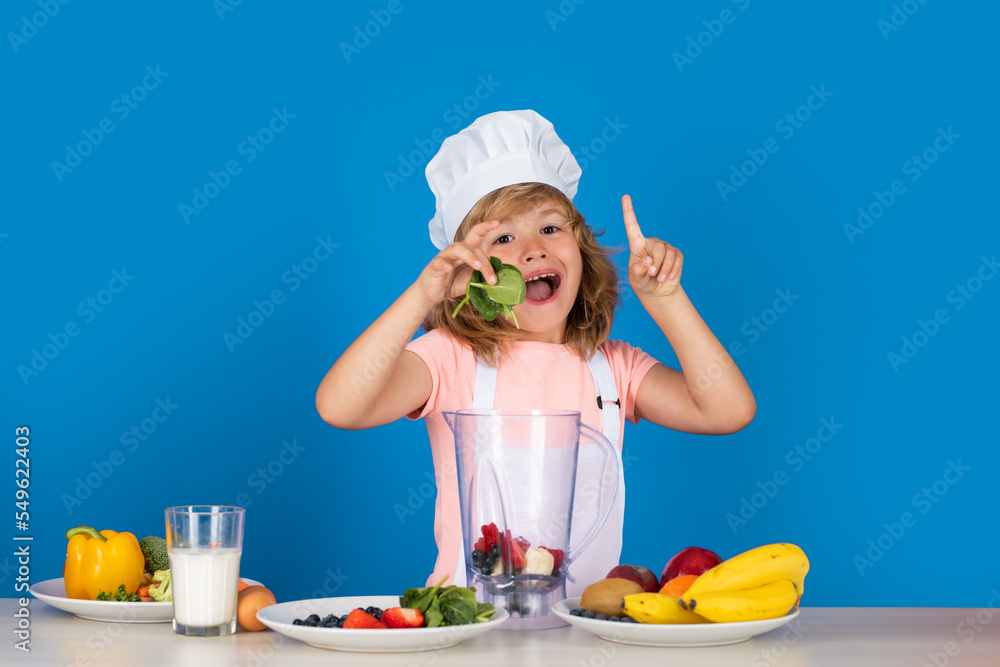 Cooking children. Chef kid boy hold spinach making fresh vegetables for healthy eat. Portrait of little child in form of cook isolated on grey background. Kid chef. Cooking process. Cooking children. Chef kid boy hold spinach making fresh vegetables for healthy eat. Portrait of little child in form of cook isolated on grey background. Kid chef. Cooking process.