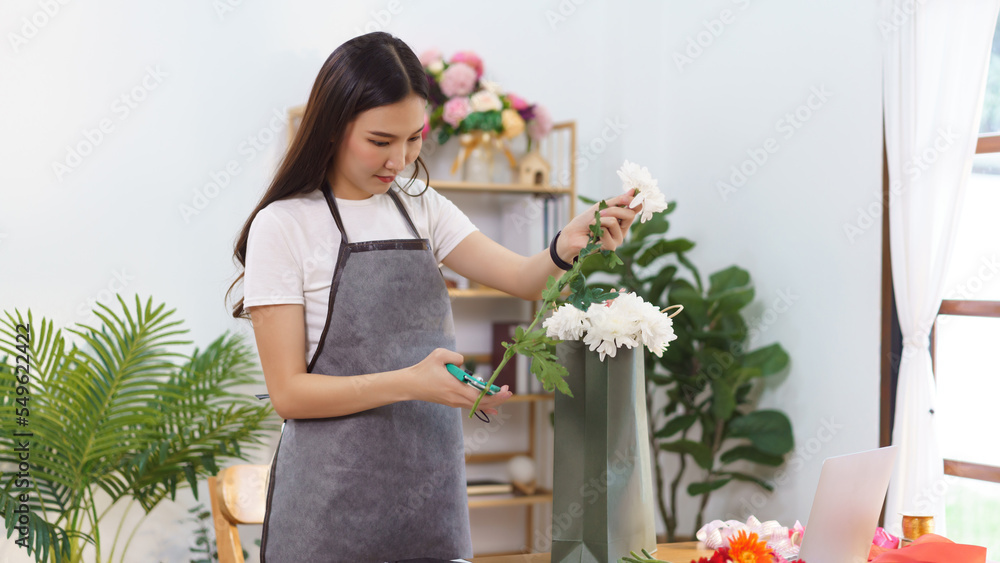 Florist concept, Female florist cut chrysanthemum stem with scissor for make flower bouquet at shop Florist concept, Female florist cut chrysanthemum stem with scissor for make flower bouquet at shop