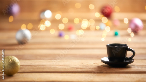 christmas lights and coffee cup on wooden background