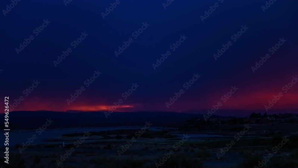 Time lapse shot of dark clouds covering orange sky after sunset time at sea Time lapse shot of dark clouds covering orange sky after sunset time at sea