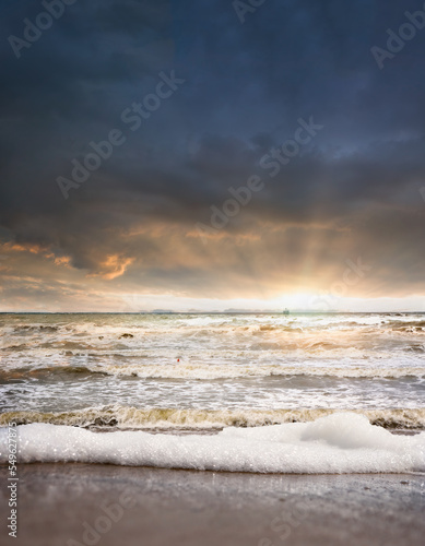 Beautiful seascape with ship in horizon and dramatic sky on sunset
