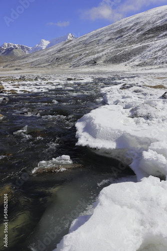 frozen mountain stream flowing through the scenic alpine valley at yumesodong or zero point, the beautiful himalayan valley located in north sikkim, india