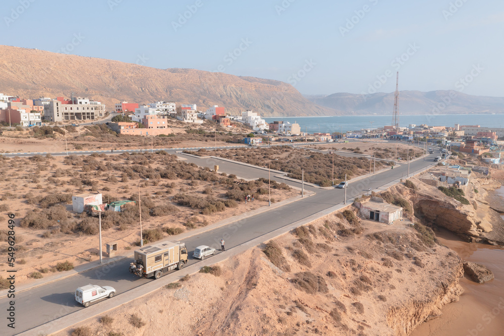 Fototapeta premium Aerial view of small fishing and surfing village of Imsoaune, Morocco. Van parked at the coast.