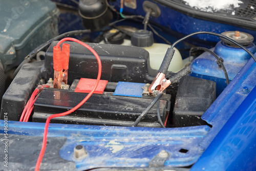 Connecting high voltage wires to the car battery. Charging automobile discharged battery