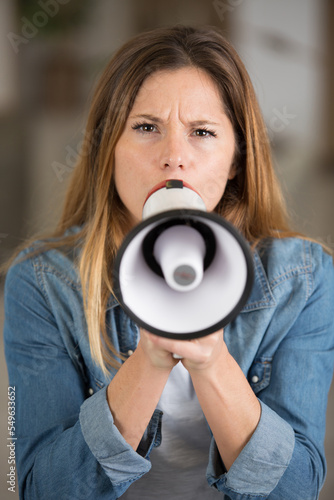 front view of woman speaking through a megaphone © auremar