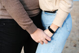 A young couple is holding hands. Hands shot close up