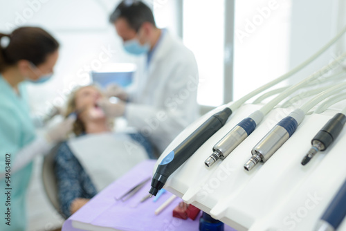 closeup of dentists implements patient in chair in background