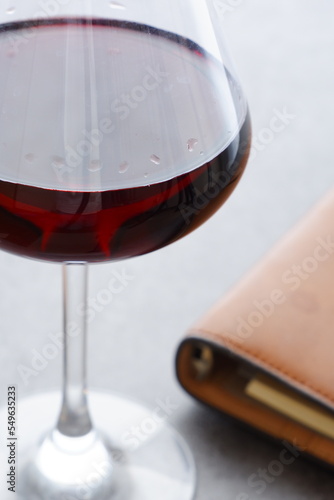 リング式のシステム手帳と赤ワインのグラス