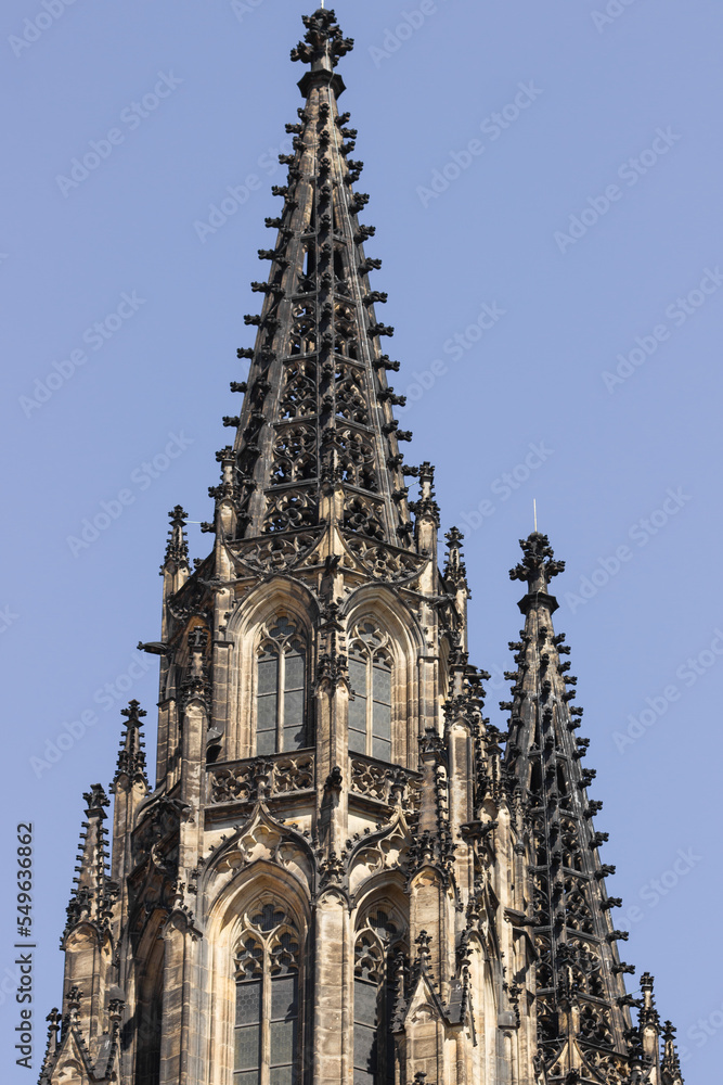 Gothic black tower of St. Vitus cathedral against blue sky in Prague Castle complex, Czech Republic. Great architecture.