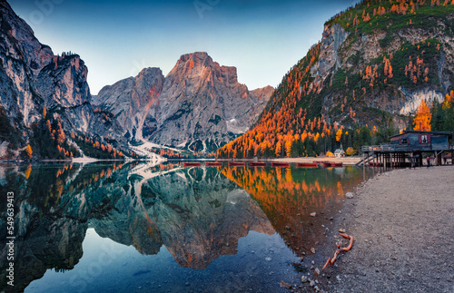 Fototapeta Naklejka Na Ścianę i Meble -  Superb autumn view of Braies (Pragser Wildsee) lake with boats and fishing dock. Magnificent dawn in Fanes-Sennes-Braies national park, Dolomite Alps, South Tyrol, Italy. Traveling concept background.