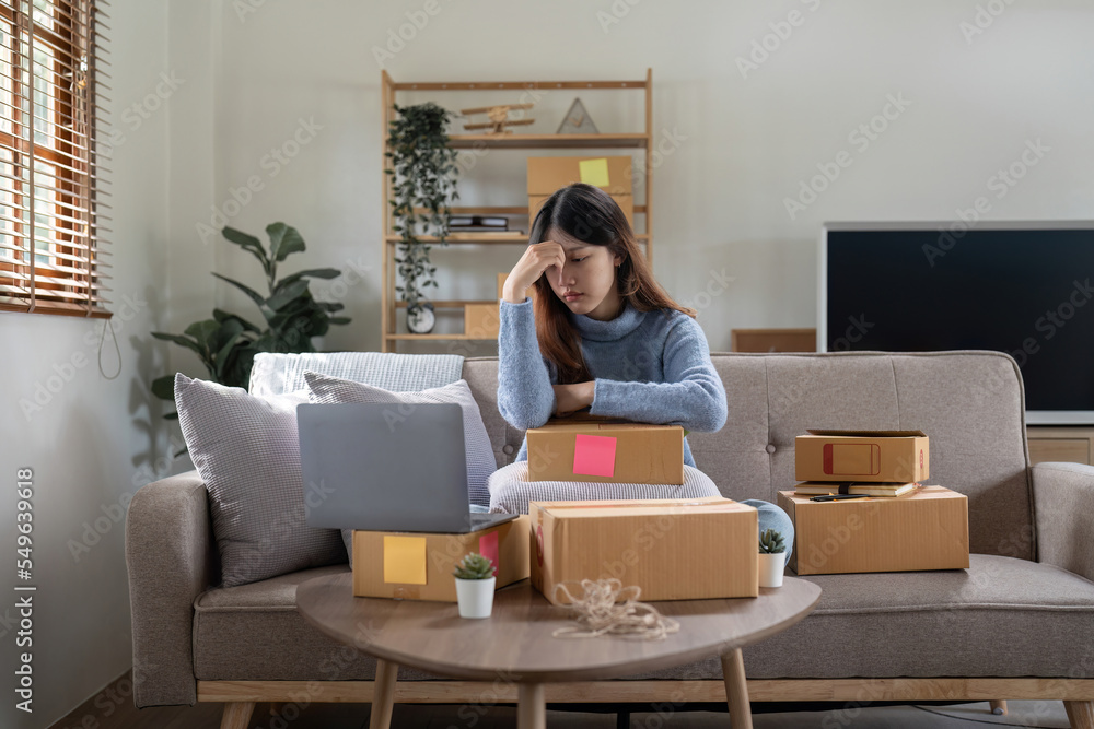 Asian woman feel worry stress and headache during waiting new order from customer home business online seller Asian woman feel worry stress and headache during waiting new order from customer home business online seller