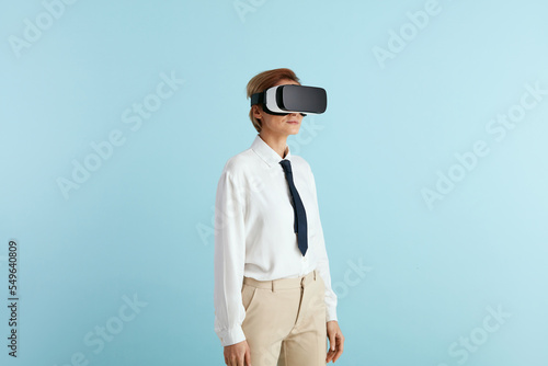 Focused Businesswoman Trying VR. Portrait of Girl Discovering New Technologies Wearing Virtual Reality Headset, Futuristic 3d Vision. Indoor Studio Shot Isolated on Blue Background  © puhhha