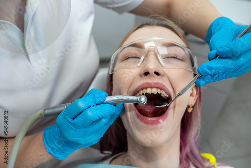 dentist examines treats decayed teeth with help special dental instruments medical equipment