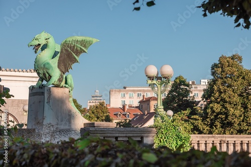 Famous dragon bridge or zmajski most, a landmark in ljublana, slovenia in early morning hours. Nobody around. Visible neboticnik skyscraper. photo