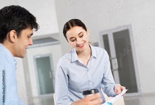 portrait of a young attractive woman discussing documents with a colleague