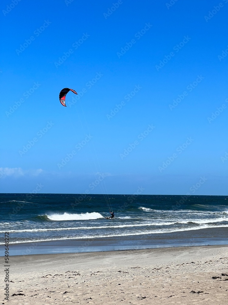 wide sandy beach blue sky with clouds visible waves over the baltic sea