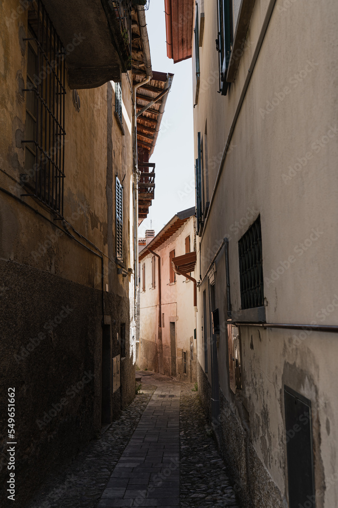 Fototapeta premium Historic ancient Italian architecture. Traditional European old town street buildings. Wooden windows, shutters and colourful pastel walls. Aesthetic summer vacation travel background