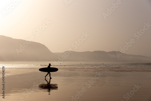 Photography Silhouette of a surfer on the beach at beautiful sunset