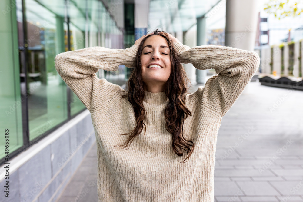 Smiling woman with head in hands standing on footpath Smiling woman with head in hands standing on footpath